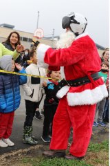A file photo of Santa with his flight helmet visiting local students. 